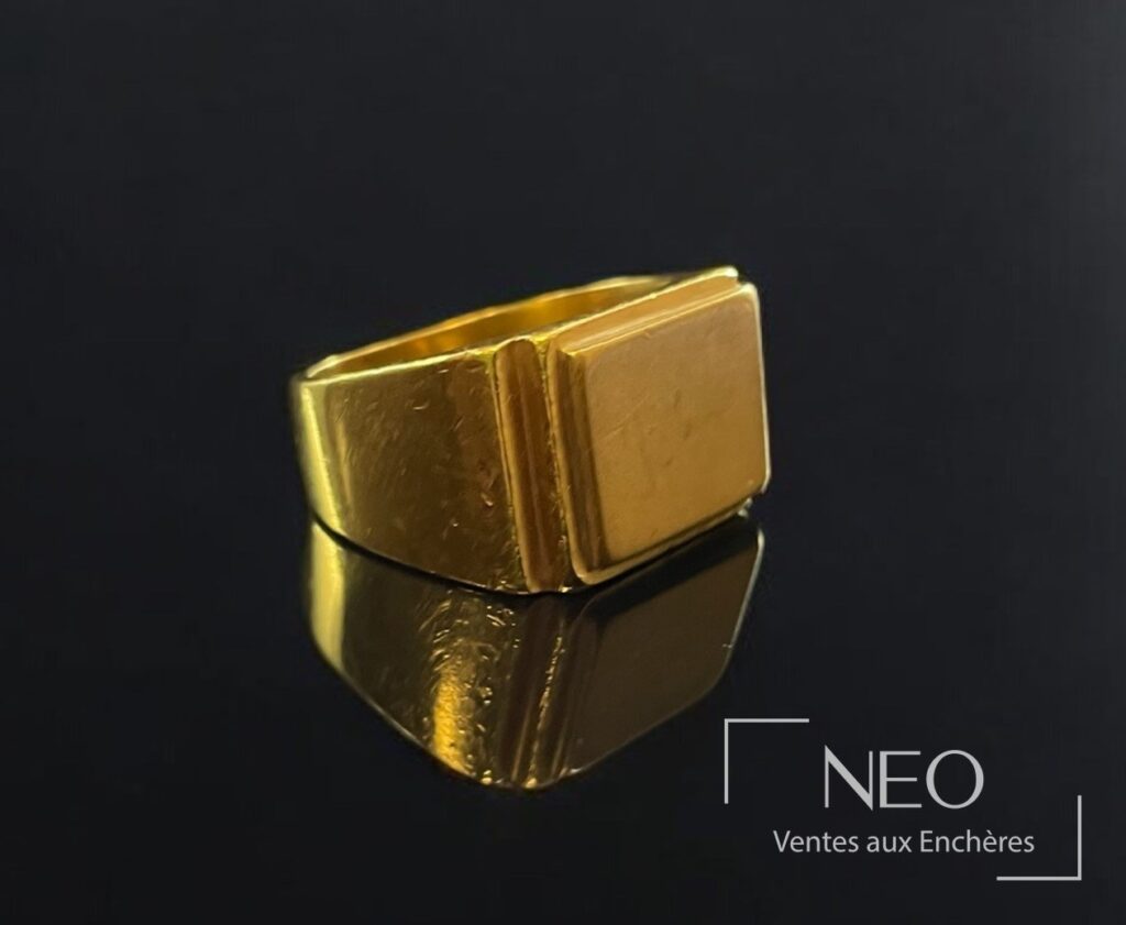 Chevalière en or jaune à plateau rectangulaire sur fond noir