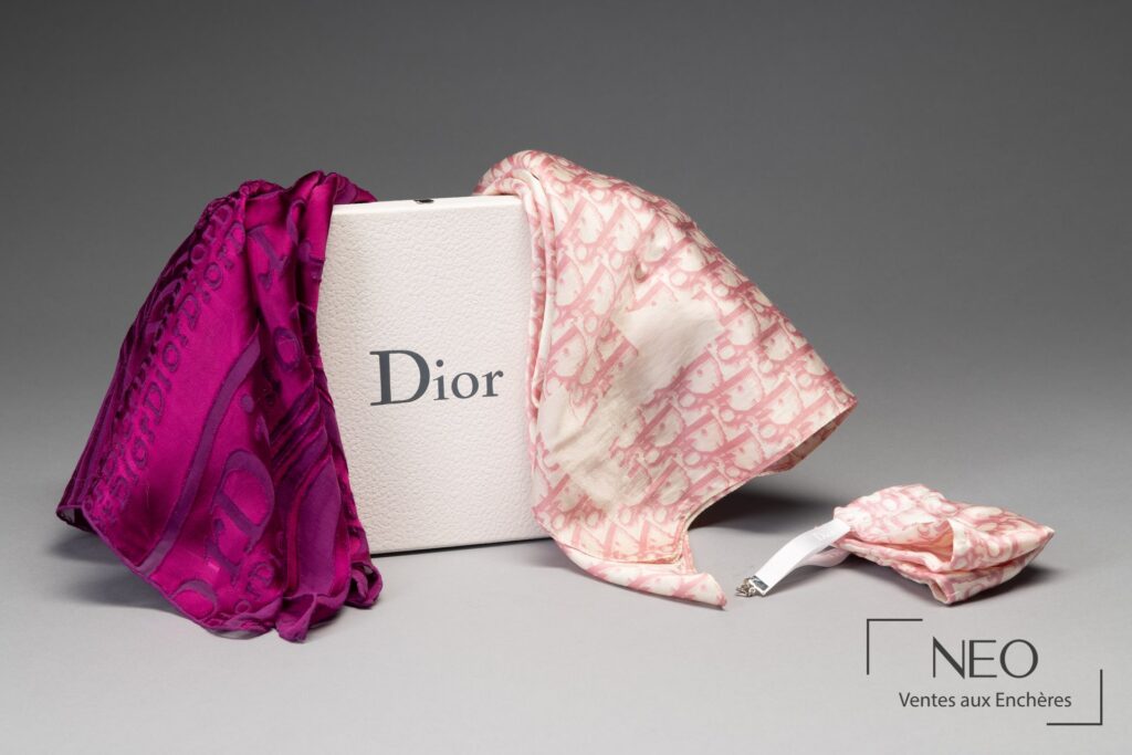 Deux foulards Christian Dior posés devant une boîte Dior