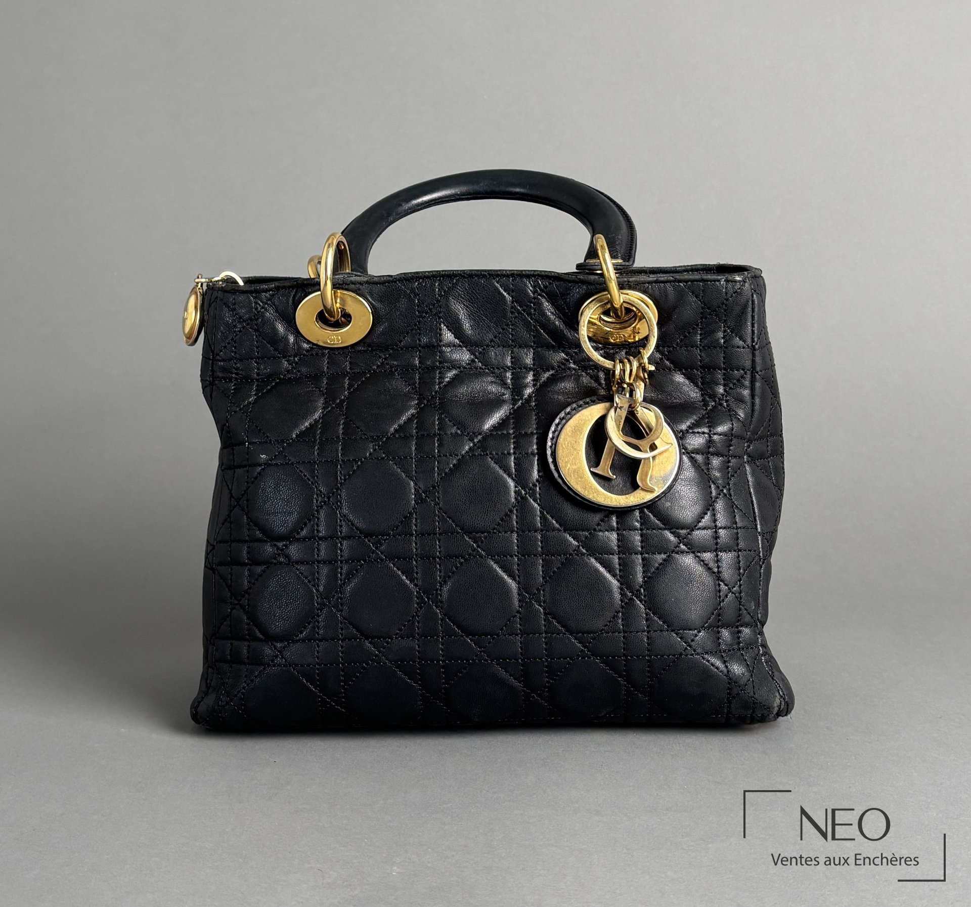 Sac Lady Dior noir matelassé avec anses et bijoux dorés