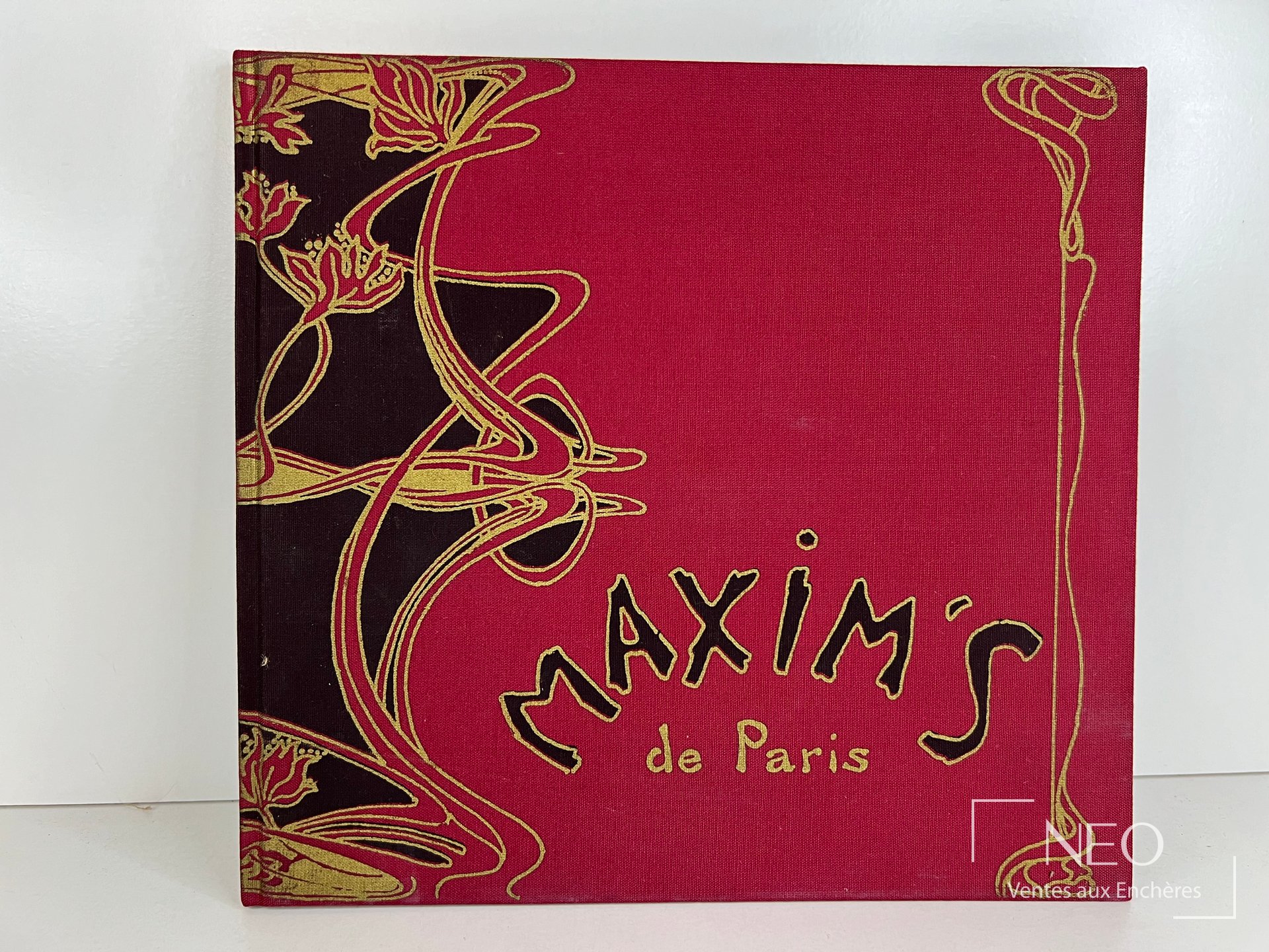 Couverture rigide illustrée rouge et noire titrée Maxim's de Paris