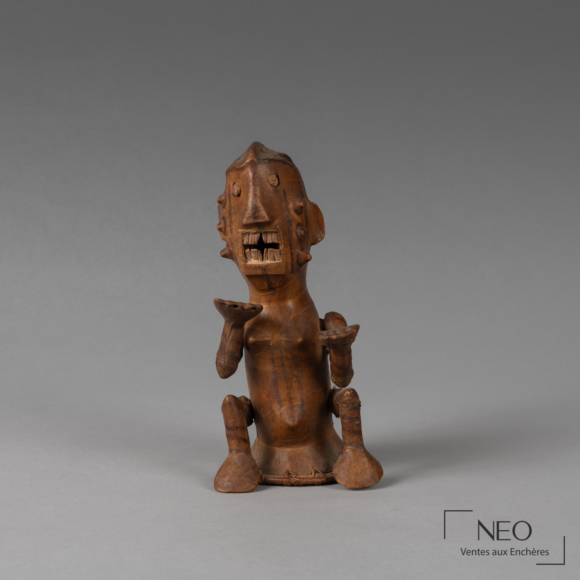 Cimier sculpté en bois représentant une figure anthropomorphe avec rotin et cuir