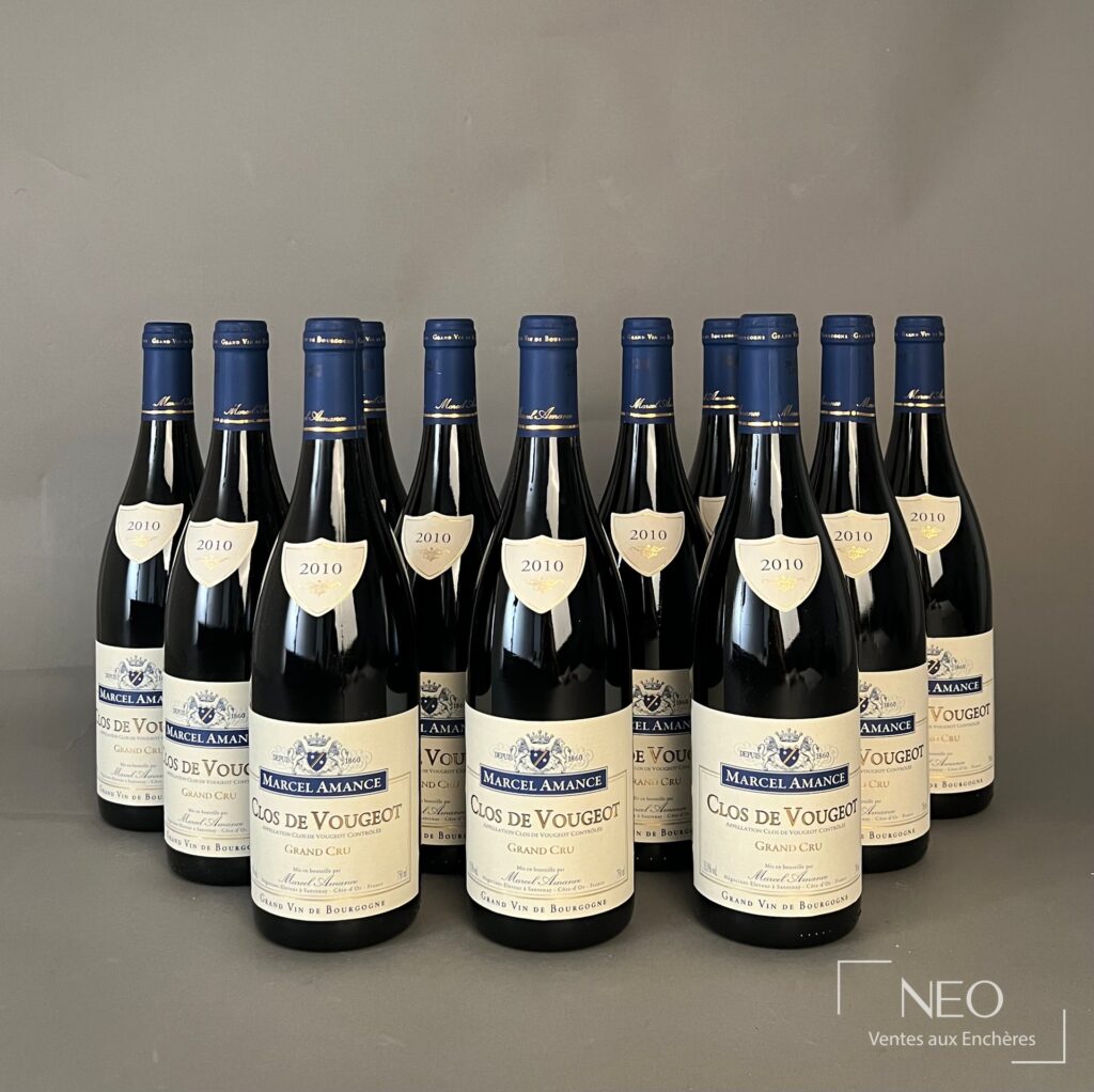Douze bouteilles de Clos de Vougeot Grand Cru Marcel Amance 2010 présentées de face.