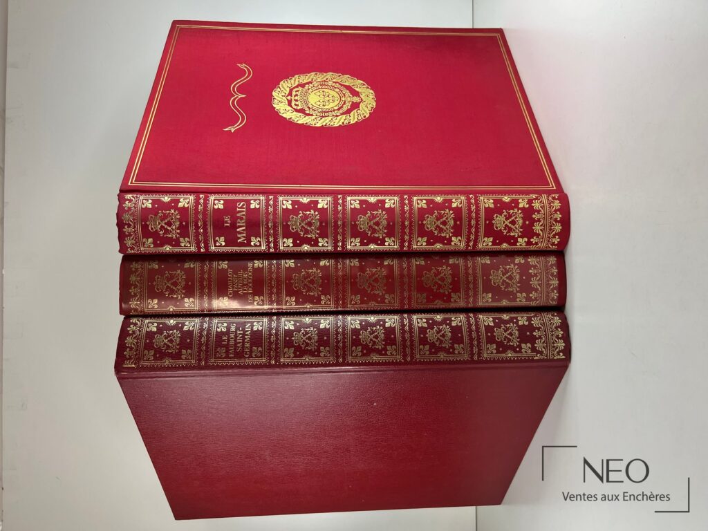 Trois volumes rouges à décor doré présentés de face