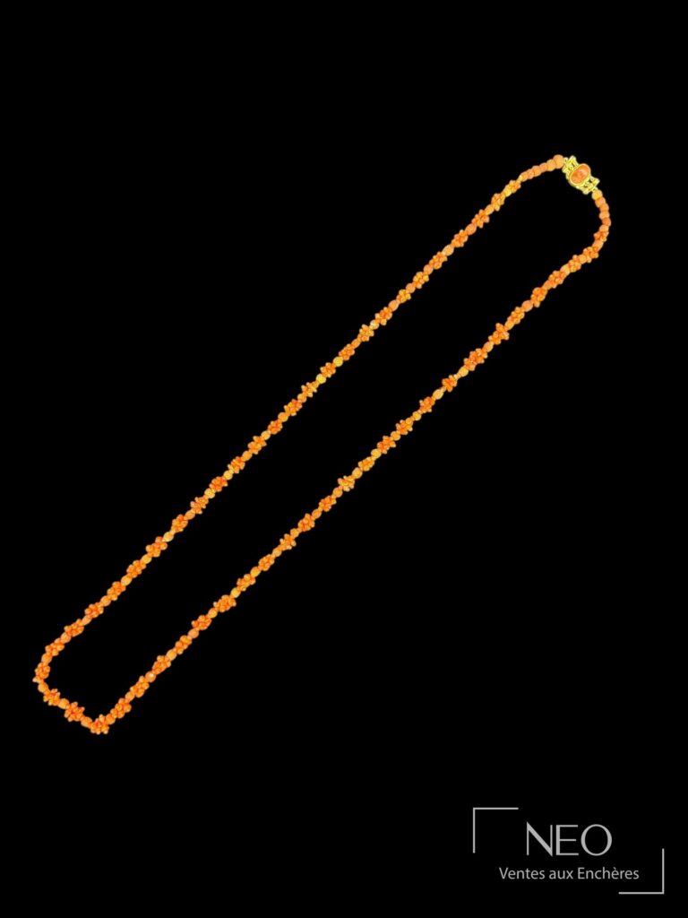Long collier de perles de corail rouge sur fond noir