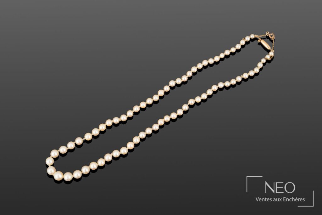 Collier de perles de culture blanches en chute sur fond gris