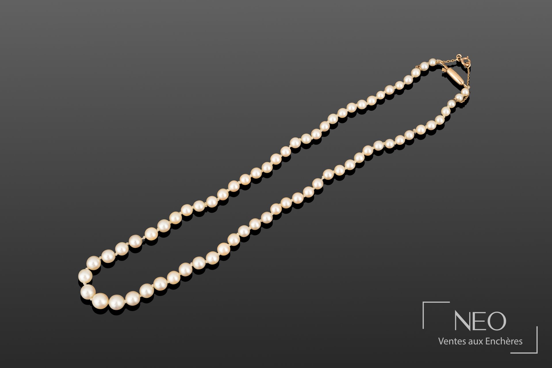 Collier de perles de culture blanches en chute sur fond gris
