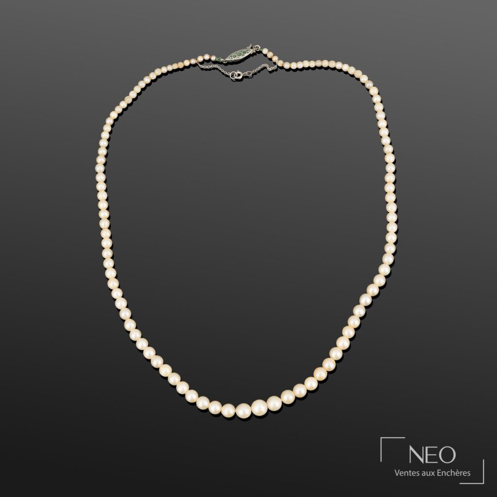 Collier de perles de culture blanches en chute sur fond gris