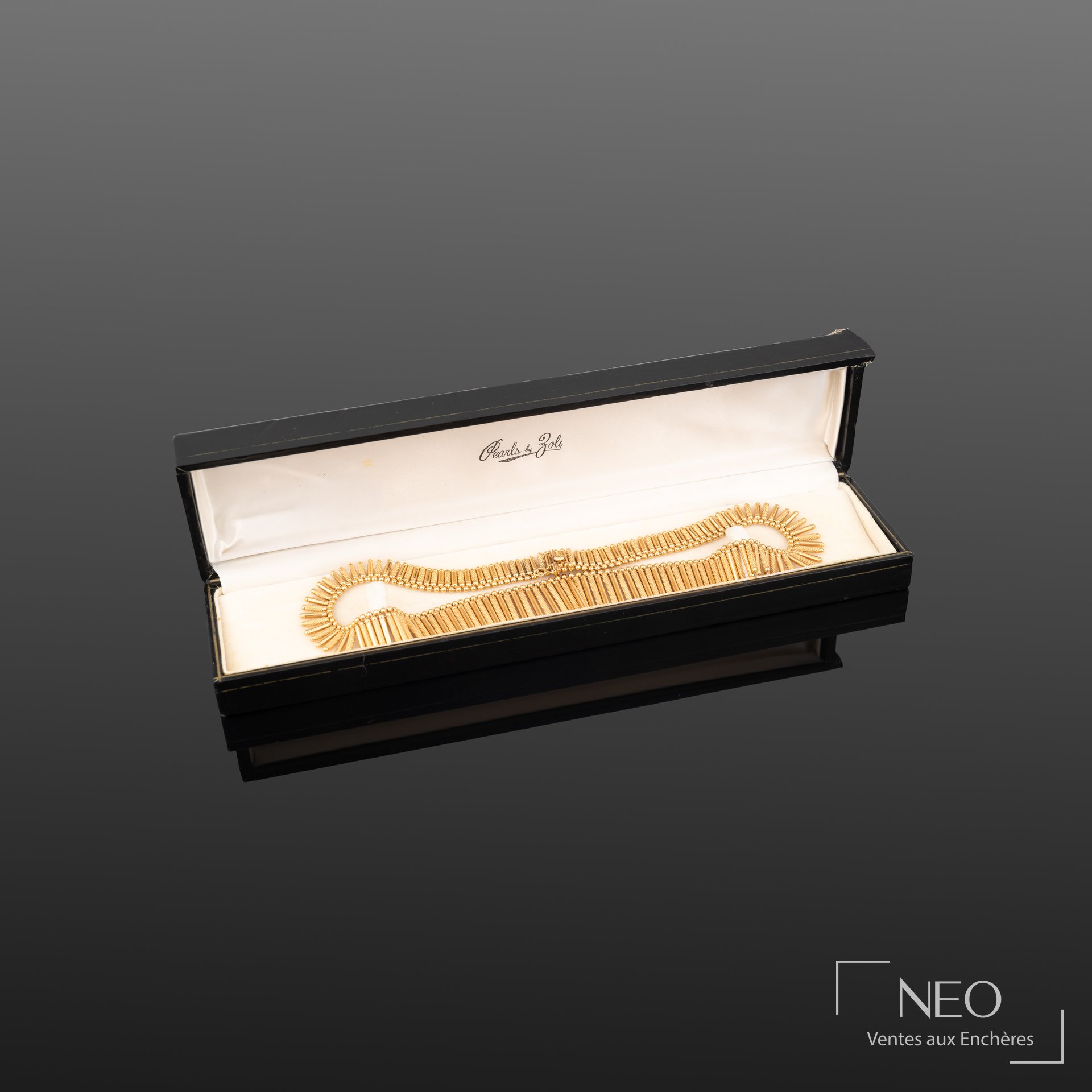 Collier draperie en or jaune présenté dans son écrin noir ouvert