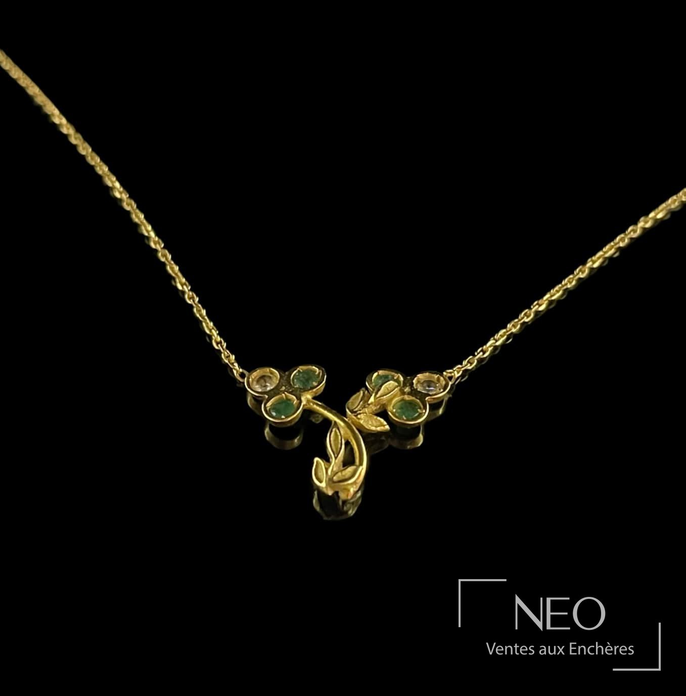 Collier en or jaune 18 carats à décor de trèfles et pierres vertes