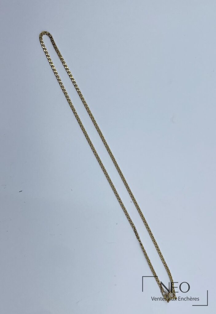 Collier en or jaune à maille souple présenté sur fond clair