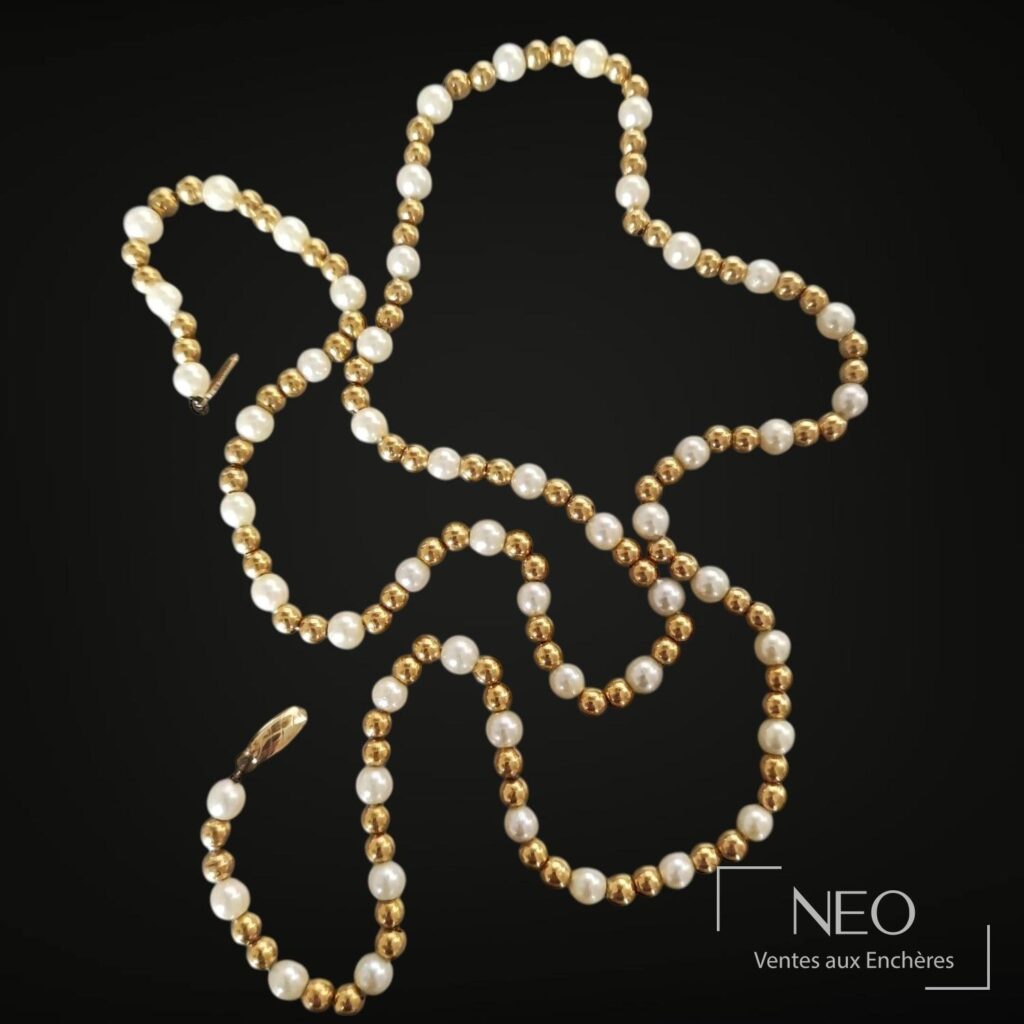 Collier en or jaune alternant perles de culture blanches et perles d’or sur fond noir