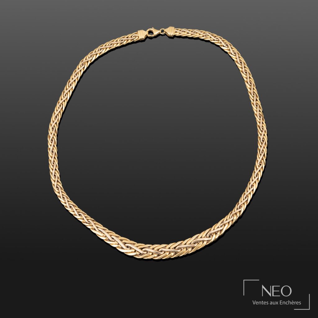 Collier en or jaune à mailles chevrons entrelacées sur fond sombre