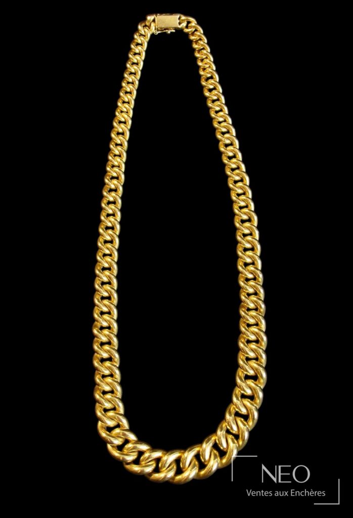 Collier en or jaune à mailles forçat présenté sur fond noir