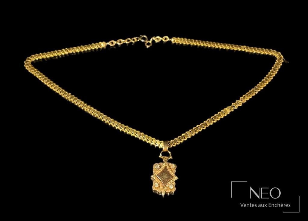 Collier en or jaune avec pendentif losange et pierres blanches sur fond noir