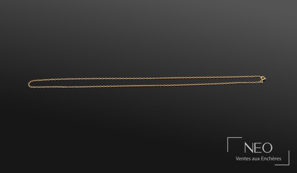 Collier en or jaune à maille forçat présenté sur fond sombre