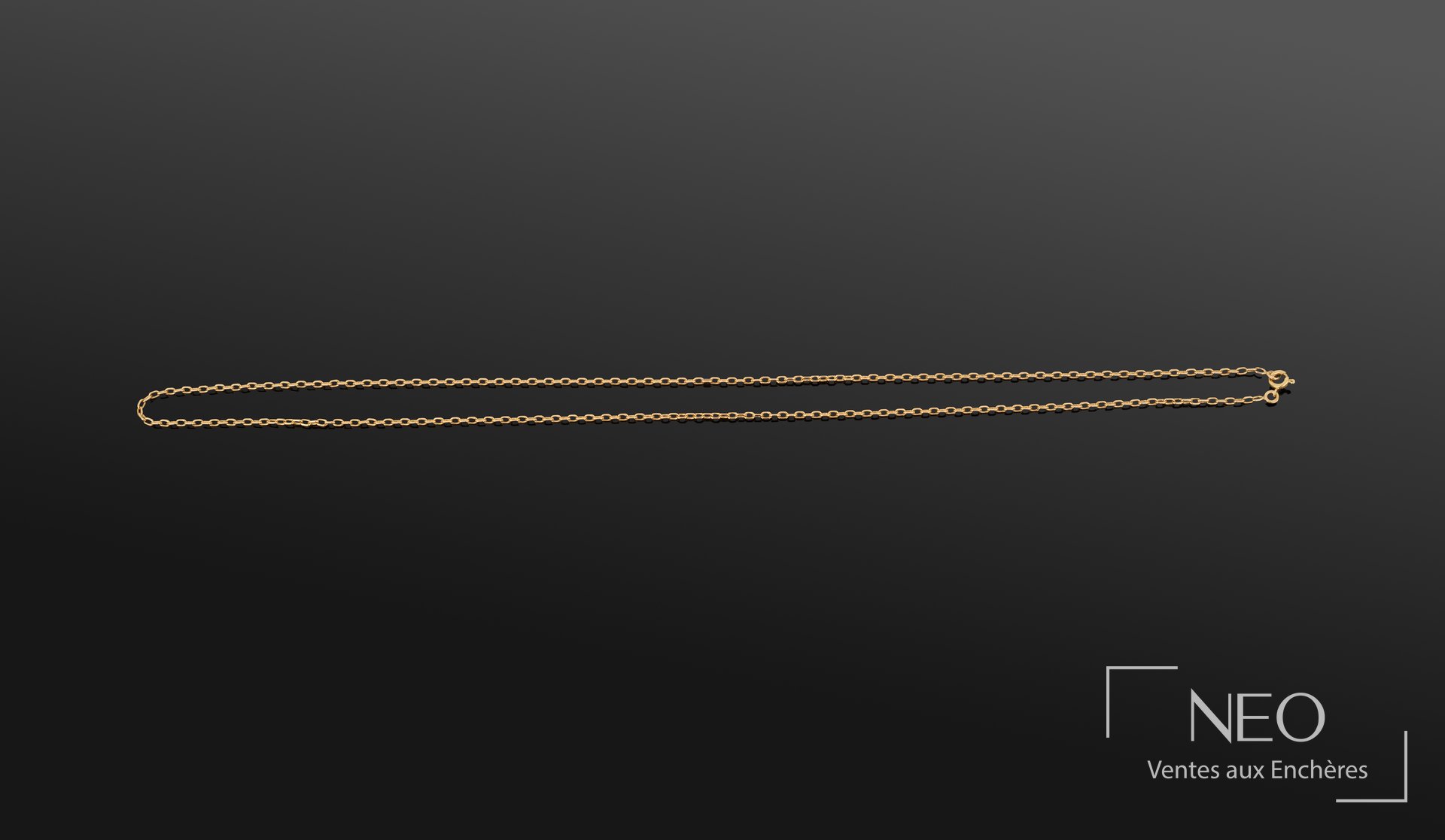 Collier en or jaune à maille forçat présenté sur fond sombre