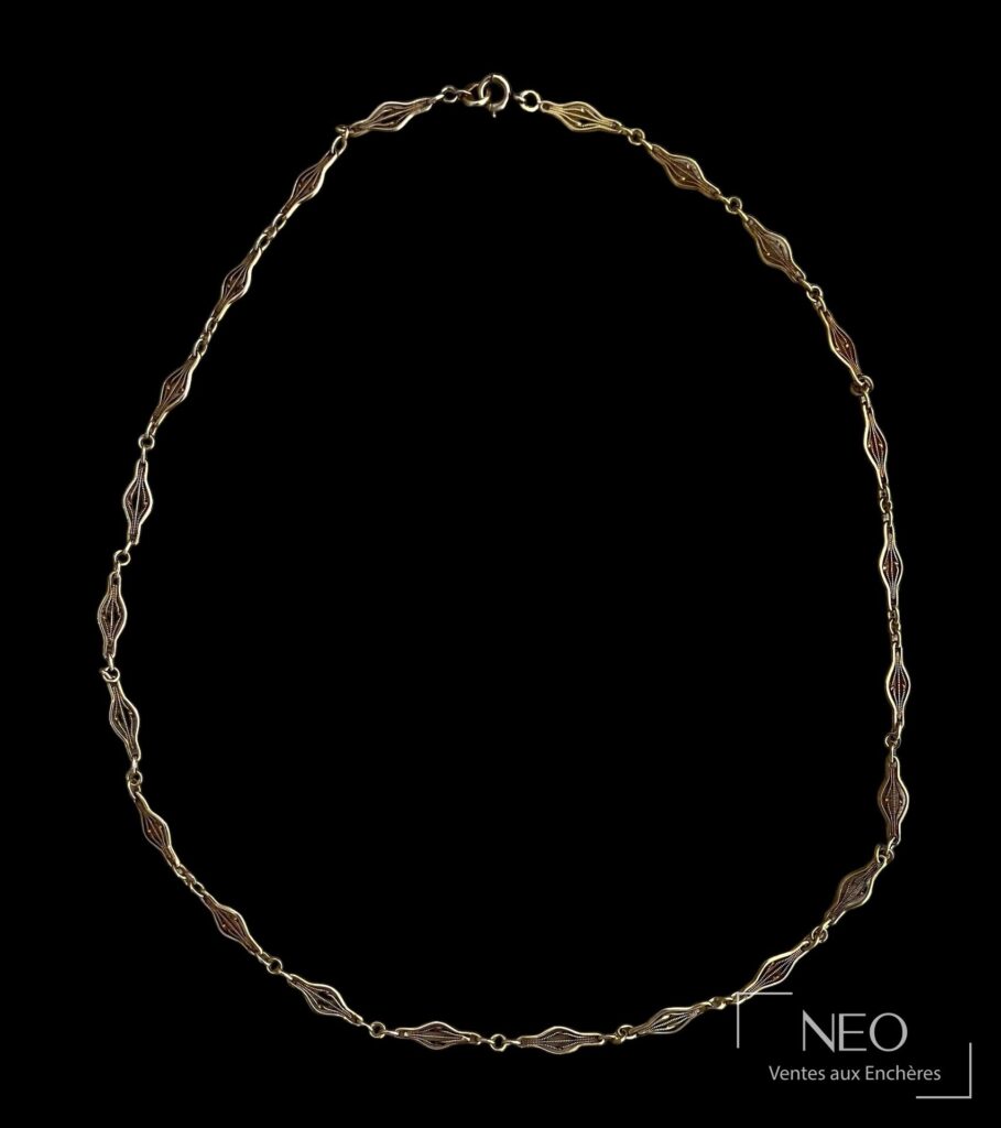 Collier en or jaune à maille fantaisie présenté sur fond noir