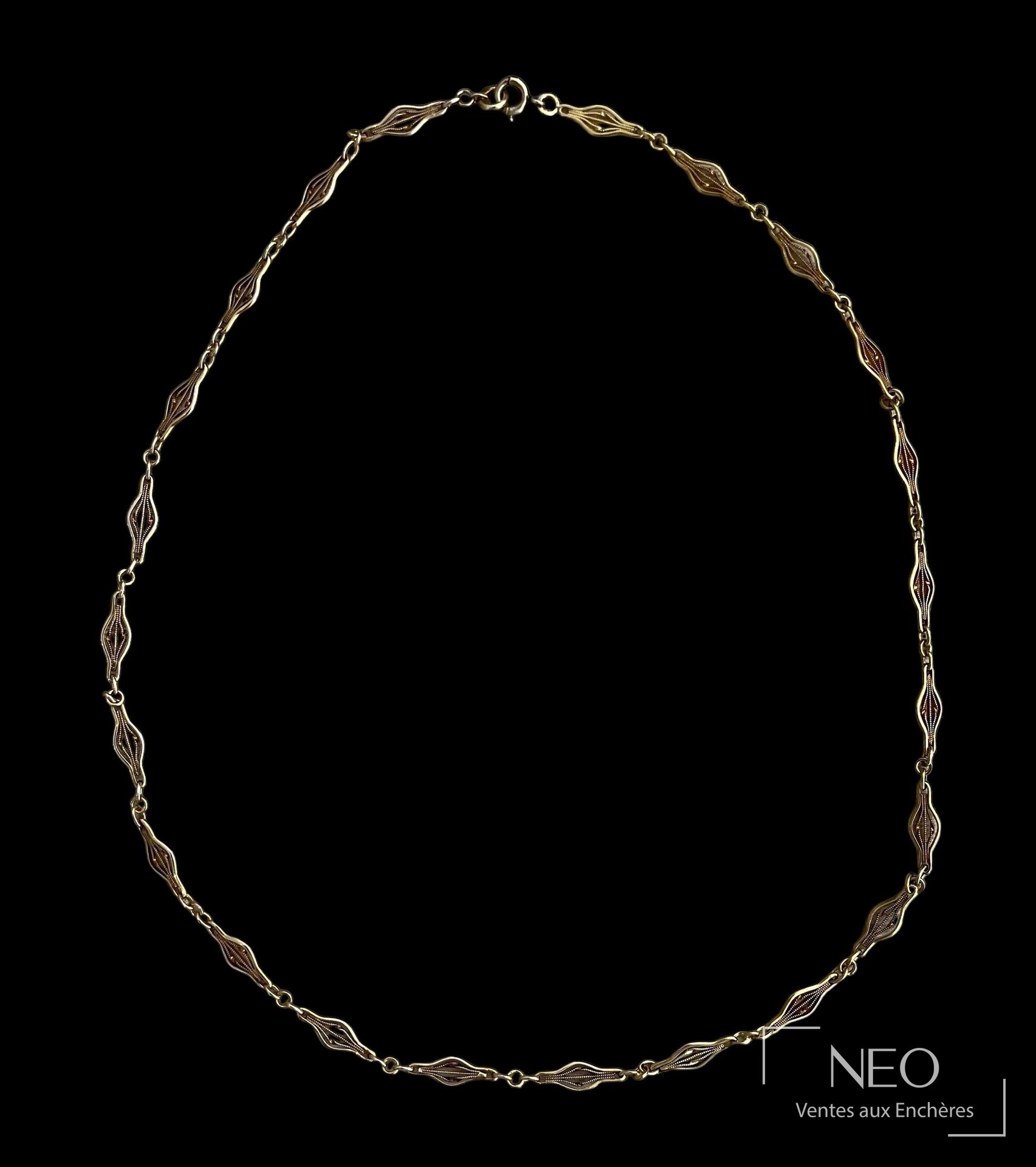 Collier en or jaune à maille fantaisie présenté sur fond noir