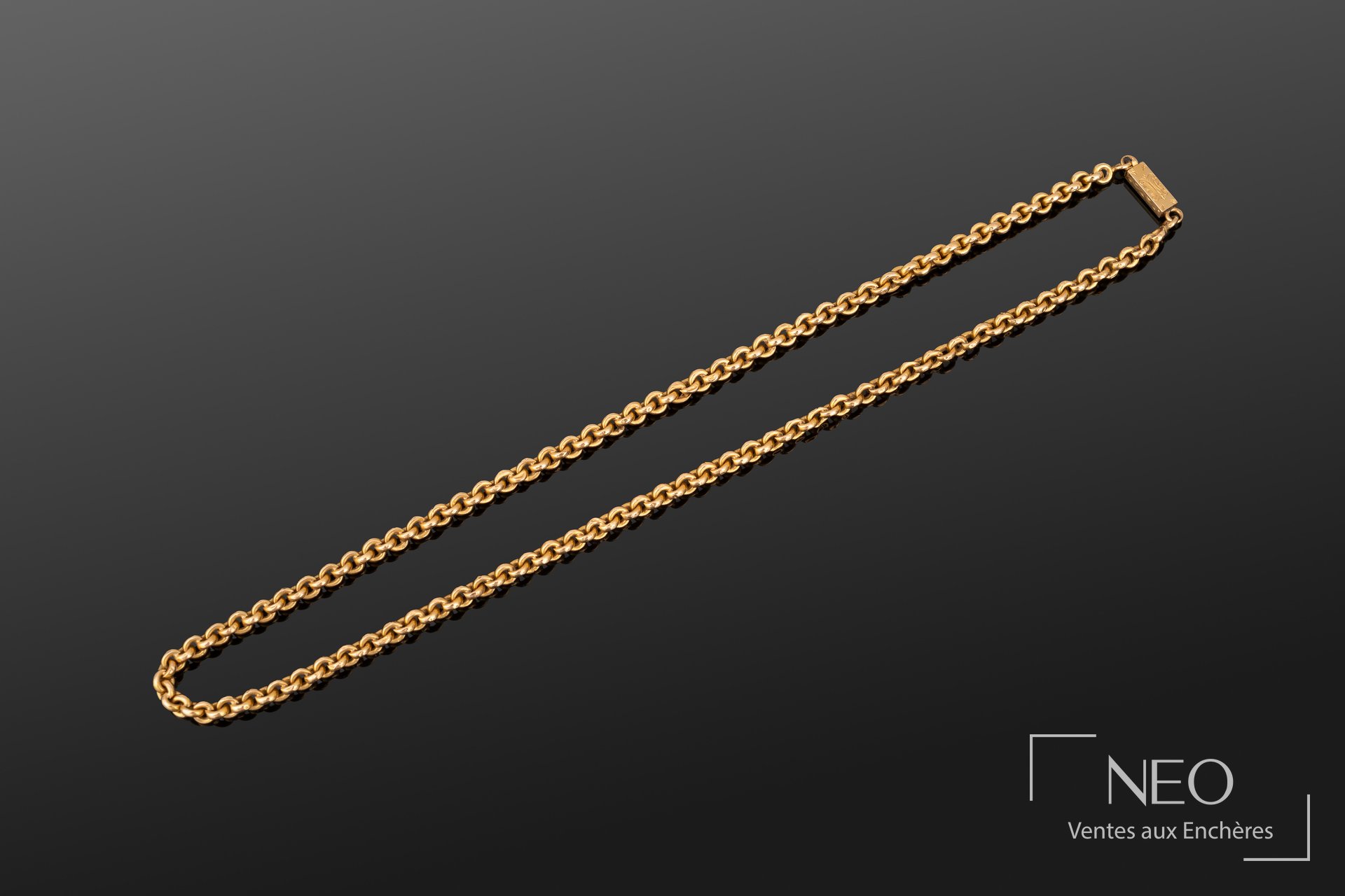 Collier en or jaune à maille jaseron présenté en entier sur fond sombre
