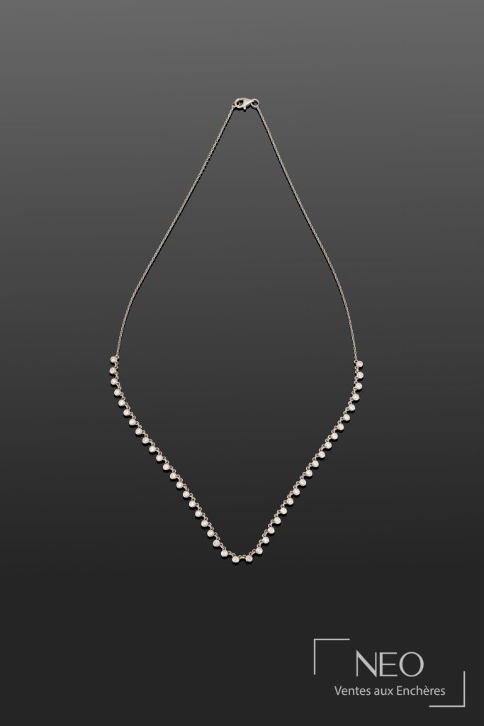 Collier ligne en or blanc avec rangée de diamants taille brillant sur fond gris