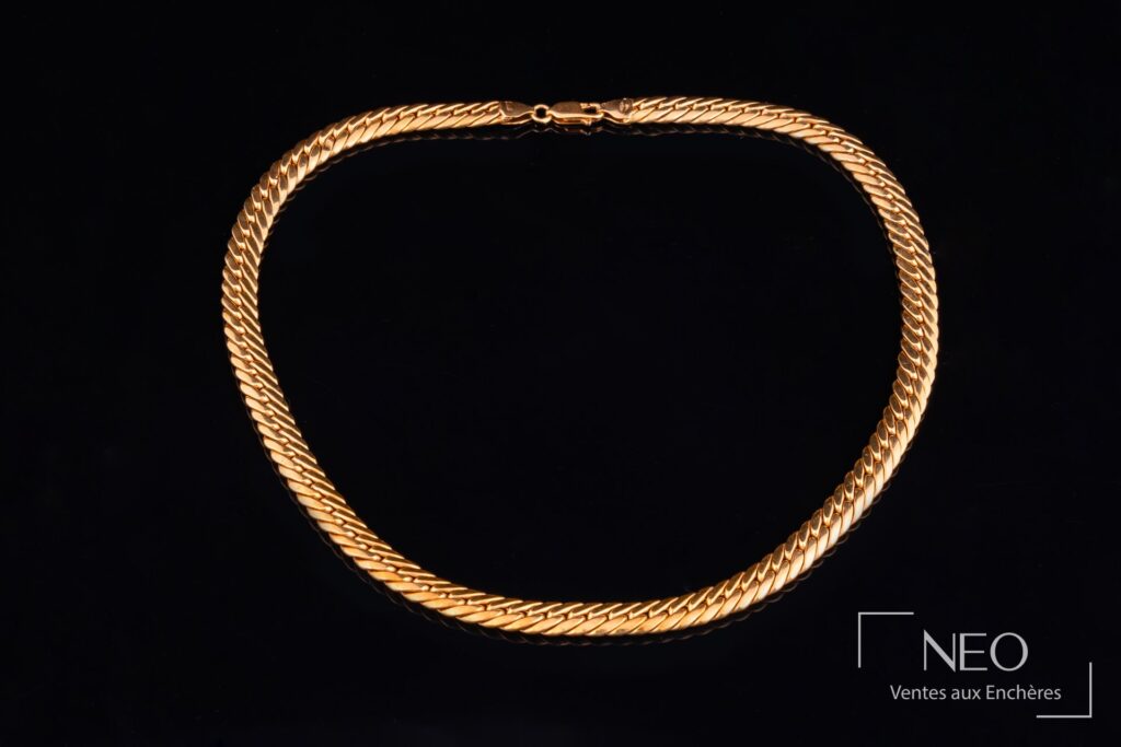 Collier à maille anglaise en or jaune sur fond noir