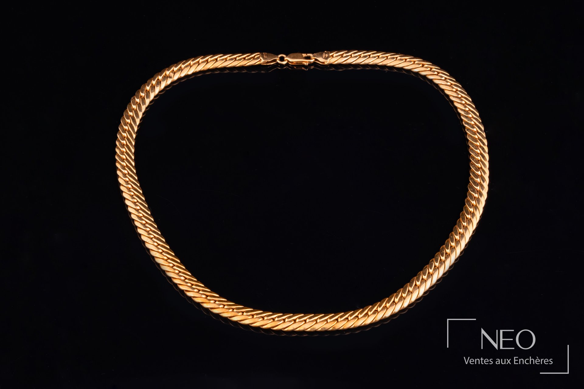 Collier à maille anglaise en or jaune sur fond noir