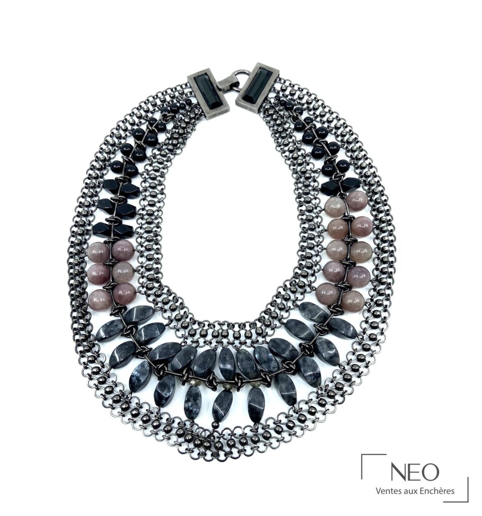 Collier multi-rangs en métal argenté avec pierres dures et verre sur fond blanc