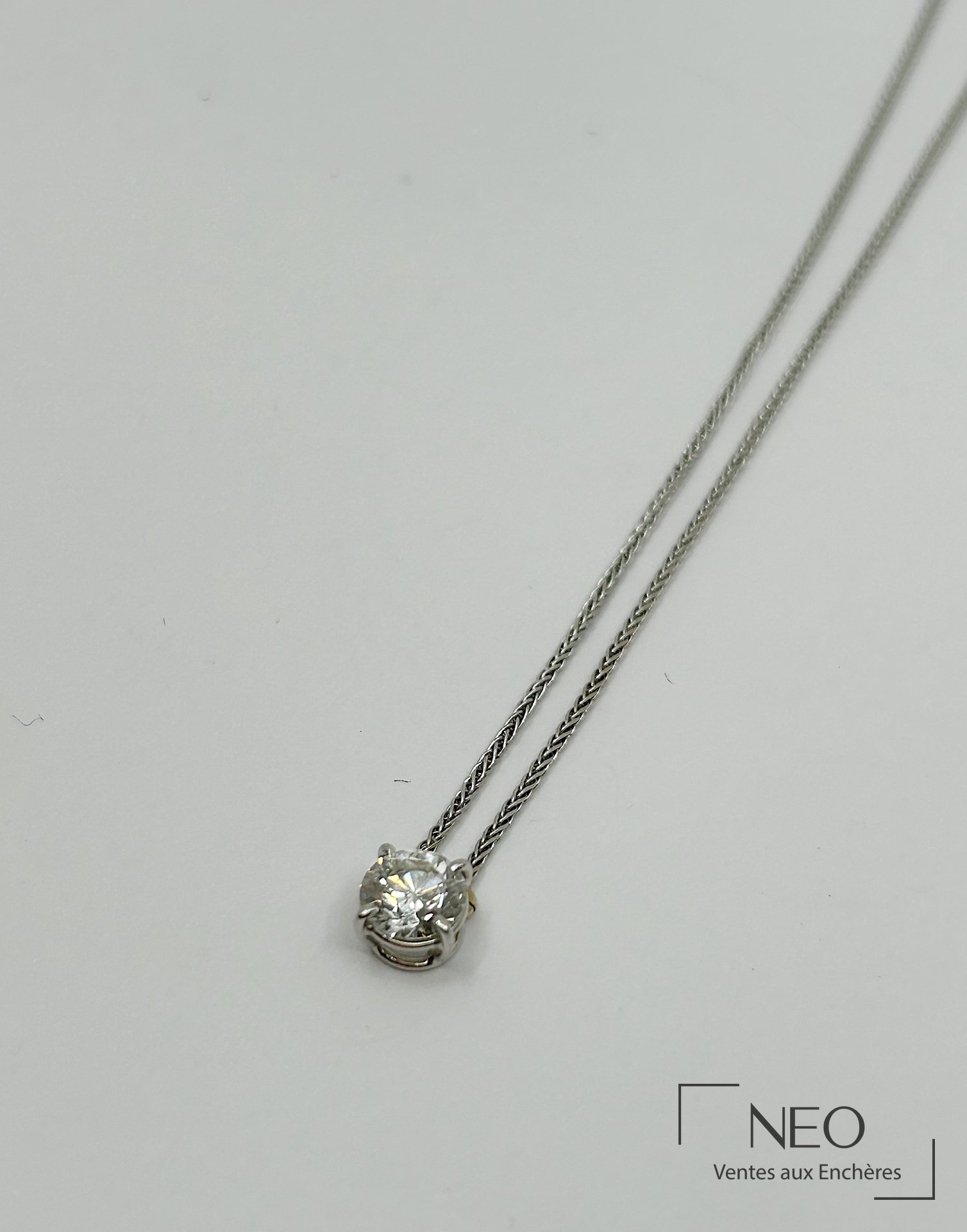 Collier en or gris avec pendentif serti d'un diamant taille brillant