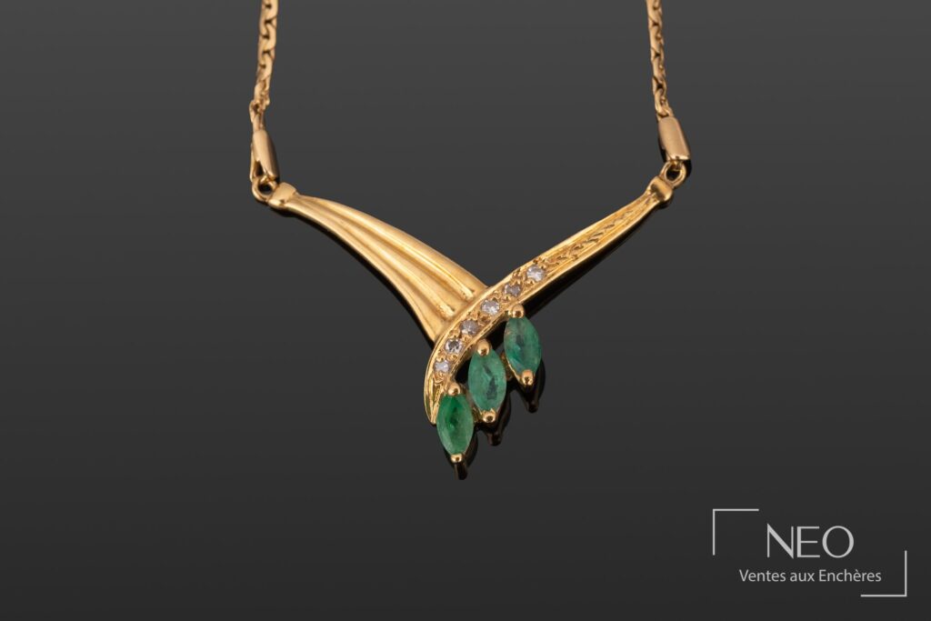 Collier en or jaune avec motif central serti de brillants et de trois émeraudes navette