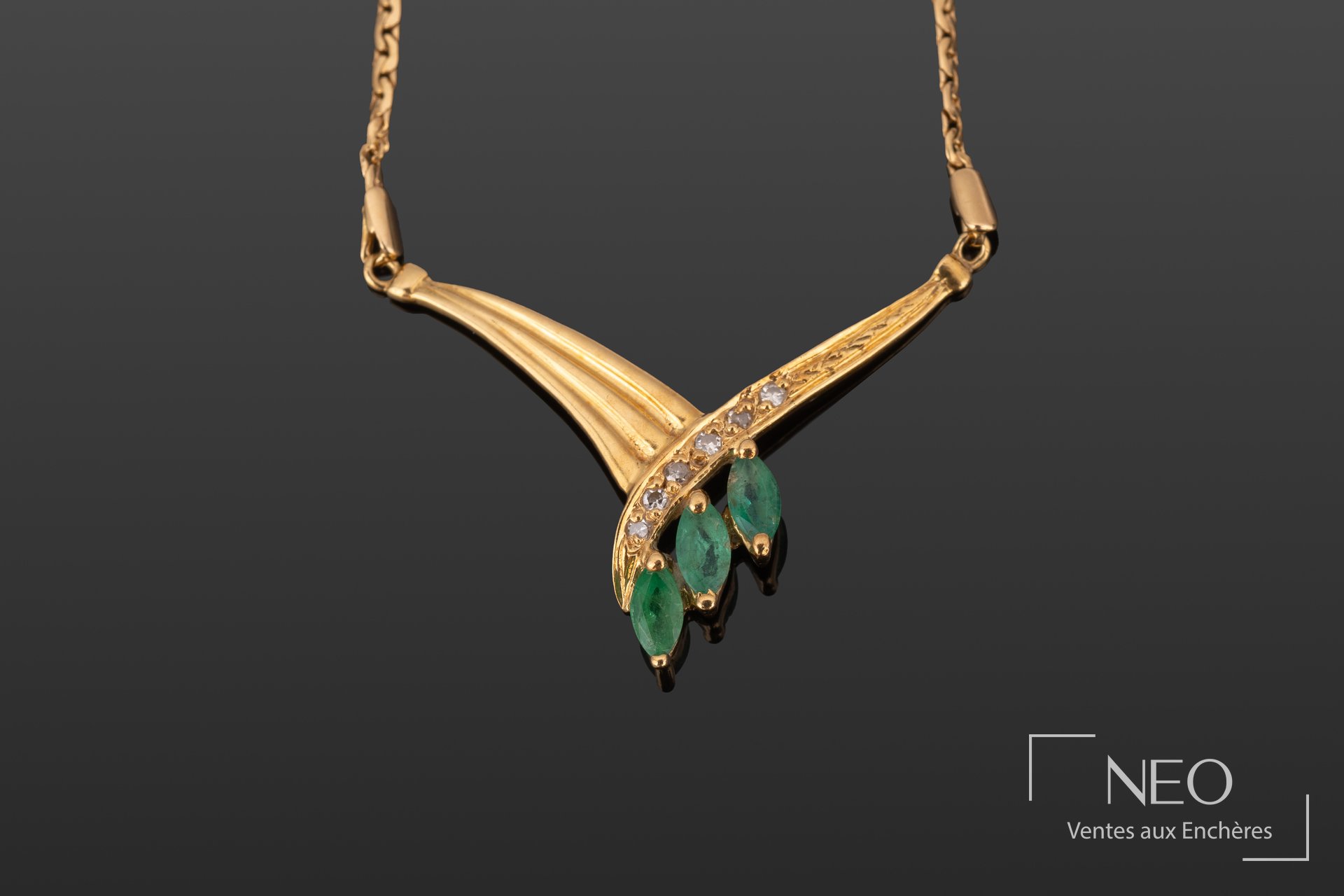 Collier en or jaune avec motif central serti de brillants et de trois émeraudes navette