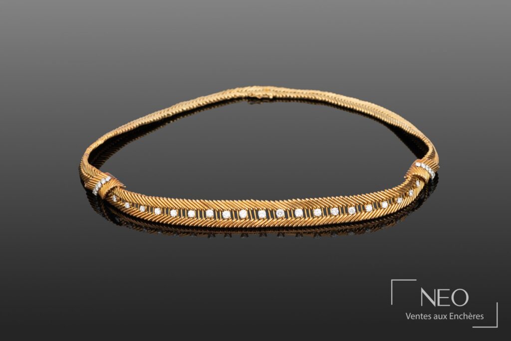 Collier en or jaune et diamants vu de face sur fond gris