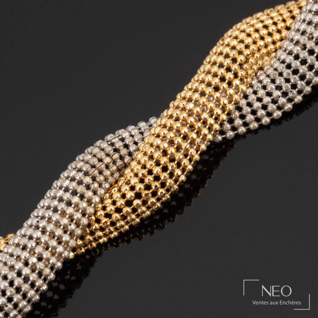Maille résille entremêlée en or jaune et or gris sur fond noir