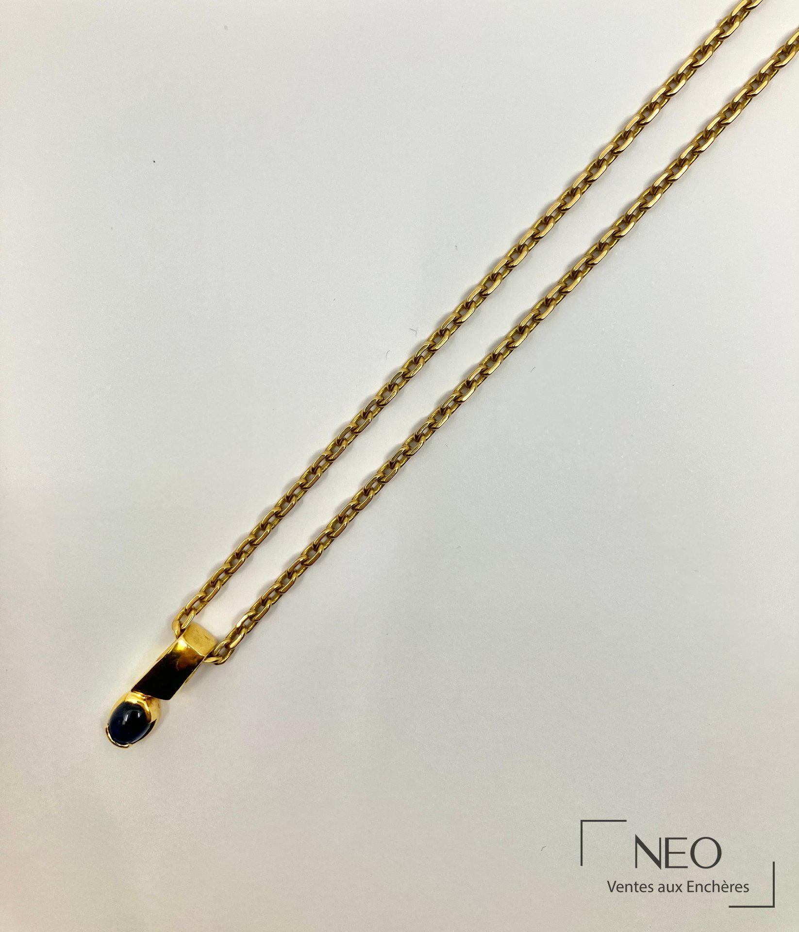 Collier en or jaune à maille forçat avec pendentif serti d’un saphir cabochon