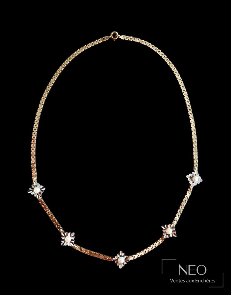 Collier en or rose et gris avec cinq fleurs stylisées et fermoir mousqueton sur fond noir