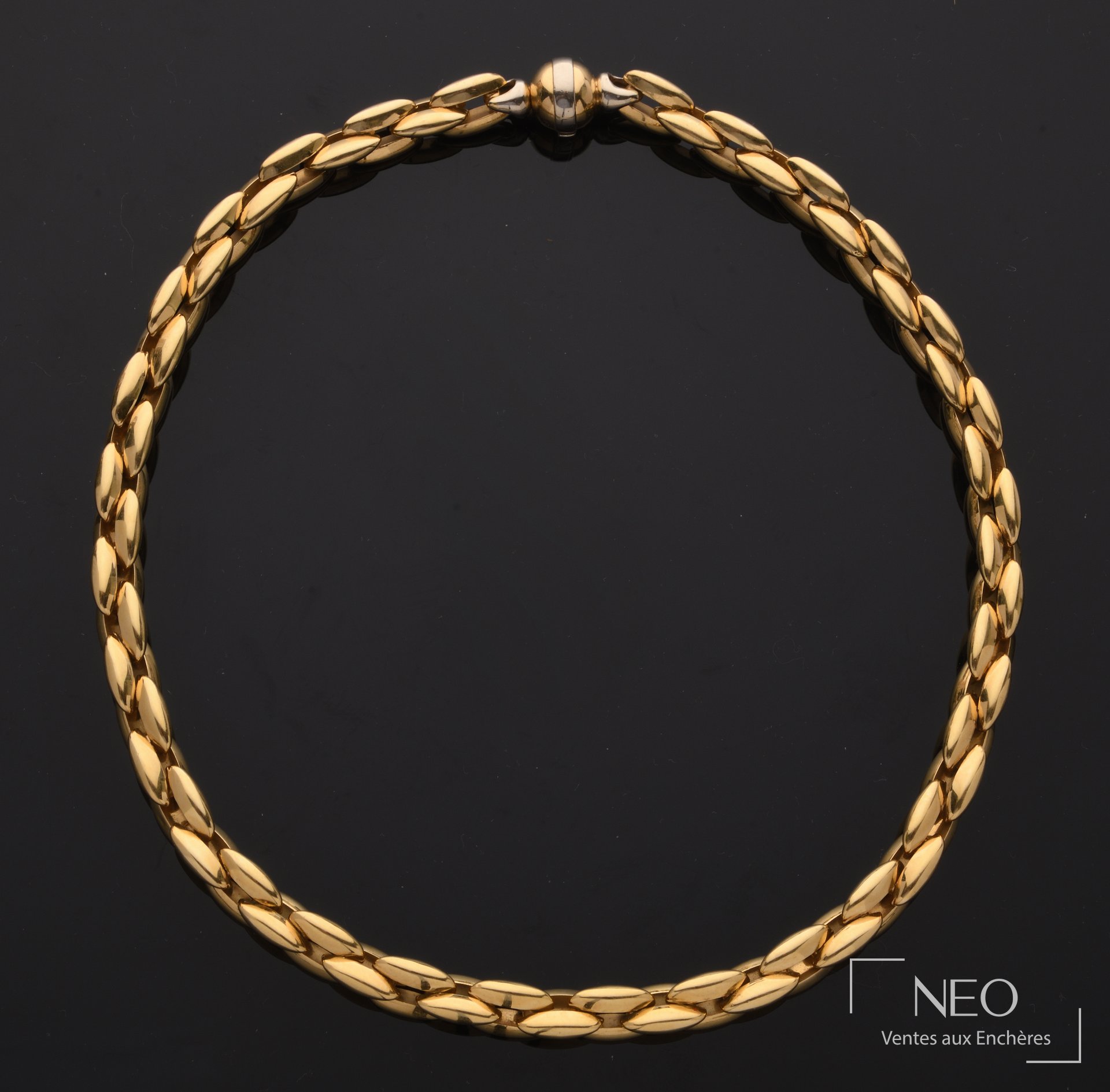 Collier en ors jaune et gris à mailles fantaisie présenté de face sur fond noir.
