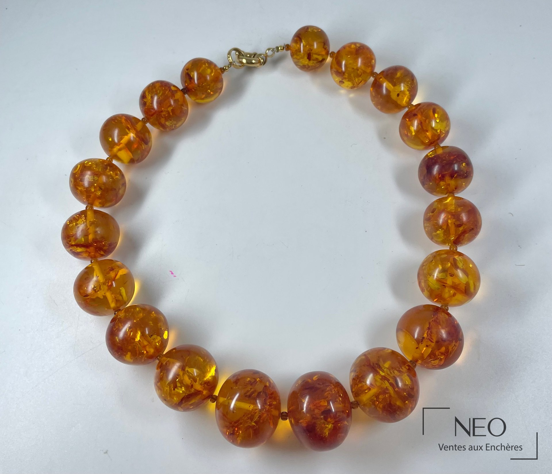 Collier en perles d'ambre monté en cercle sur fond clair