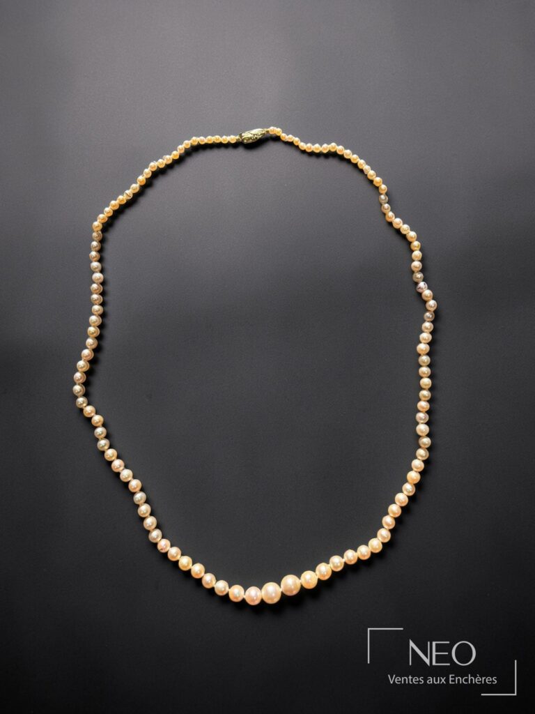 Collier de perles fines en chute présenté de face sur fond noir