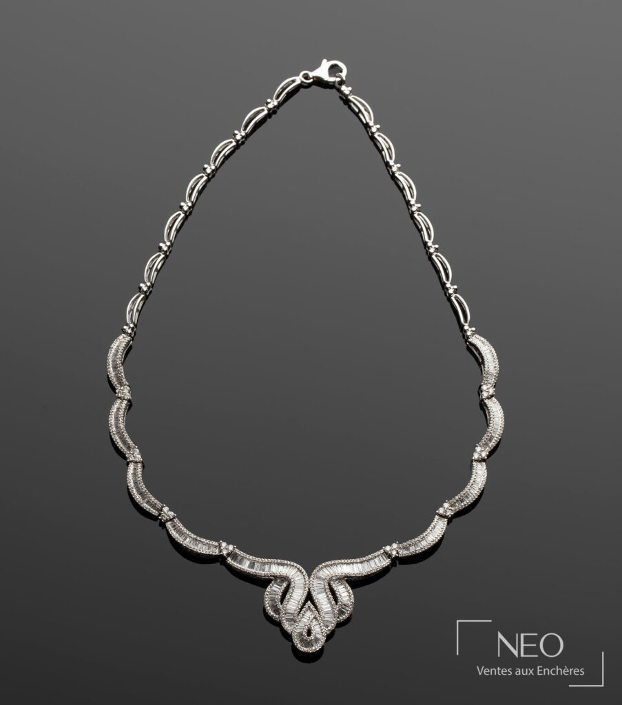 Collier plastron en or gris serti de diamants sur fond gris