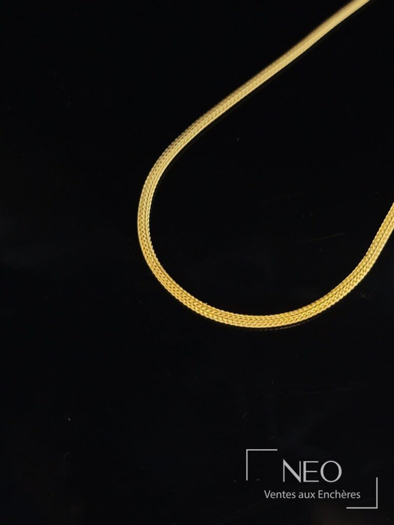 Collier ras de cou en or jaune à maille palmier sur fond noir
