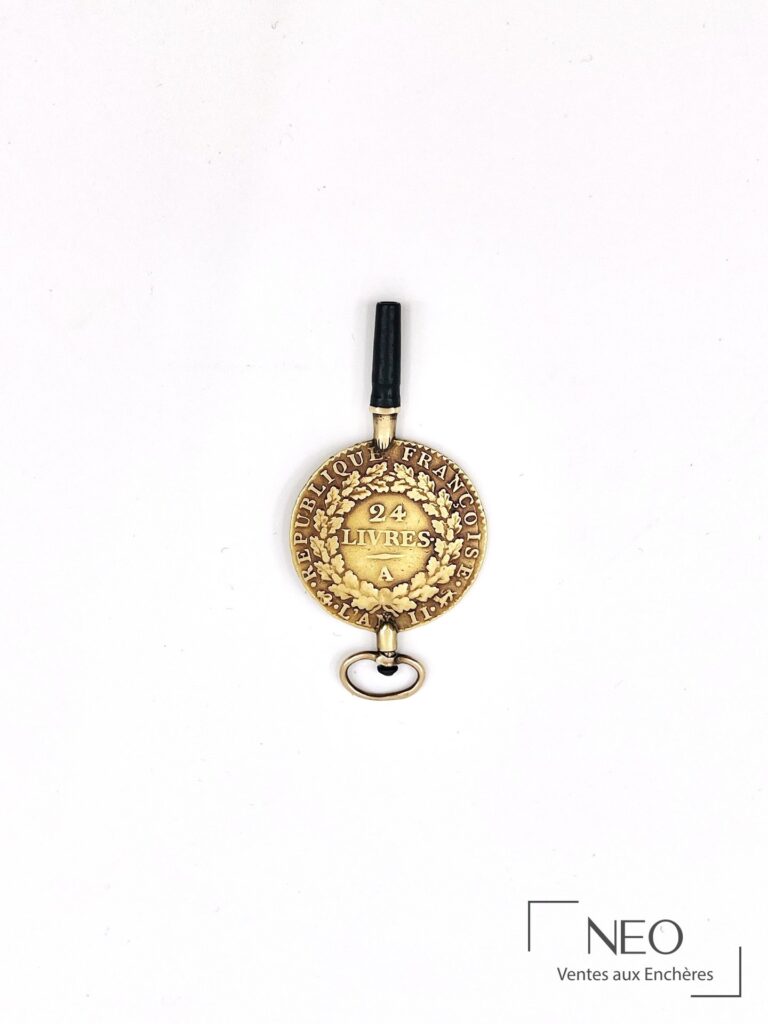 Pendentif rond en or jaune avec inscription 24 livres et élément noir en partie haute