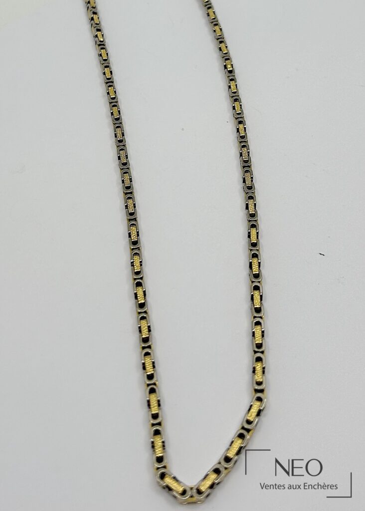 Collier sautoir en or jaune et gris à double maille souple sur fond clair