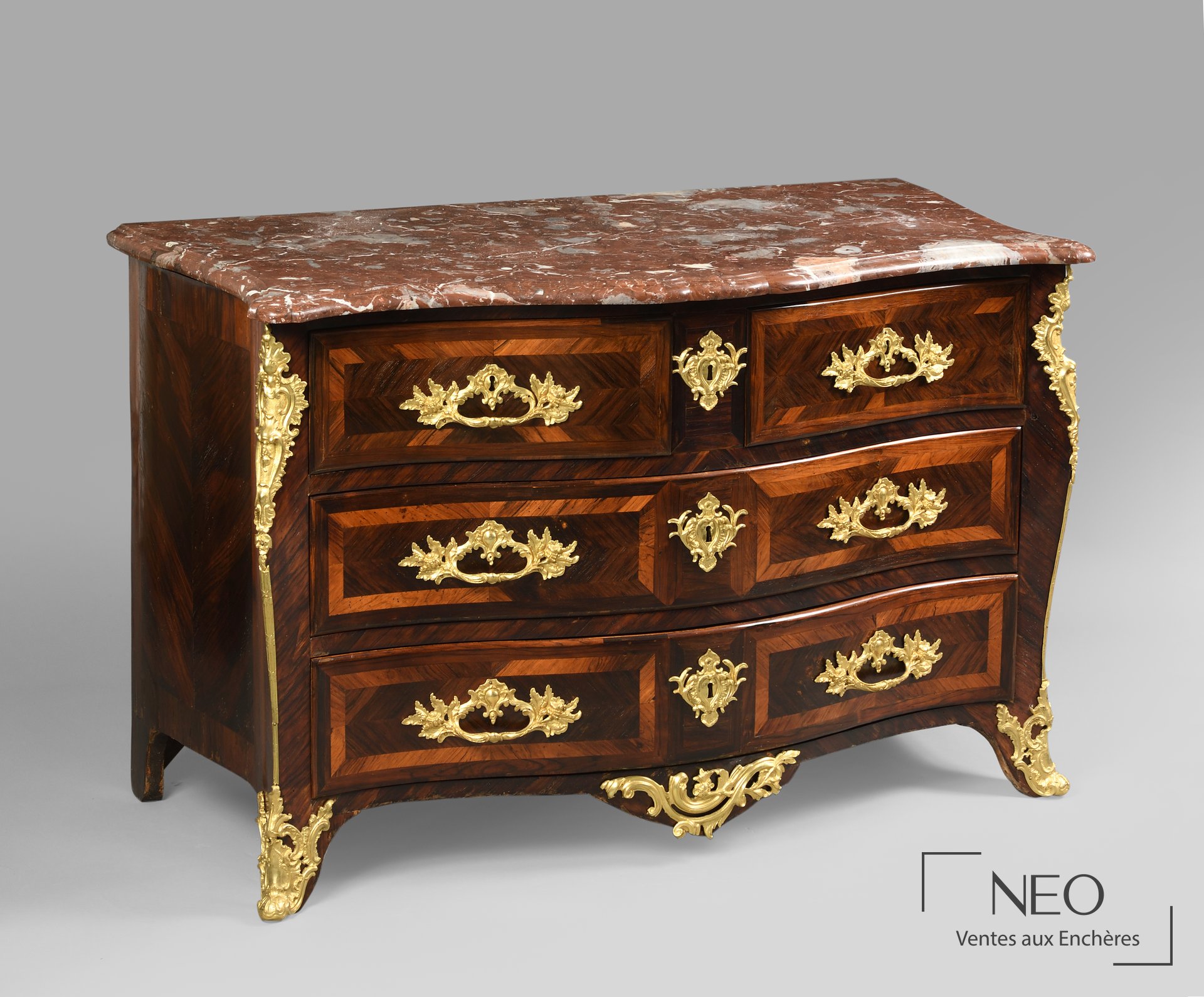 Commode tombeau en bois de placage à façade mouvementée