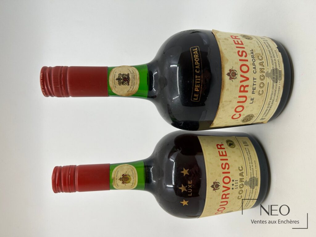 Deux bouteilles de cognac Courvoisier présentées de face sur fond clair
