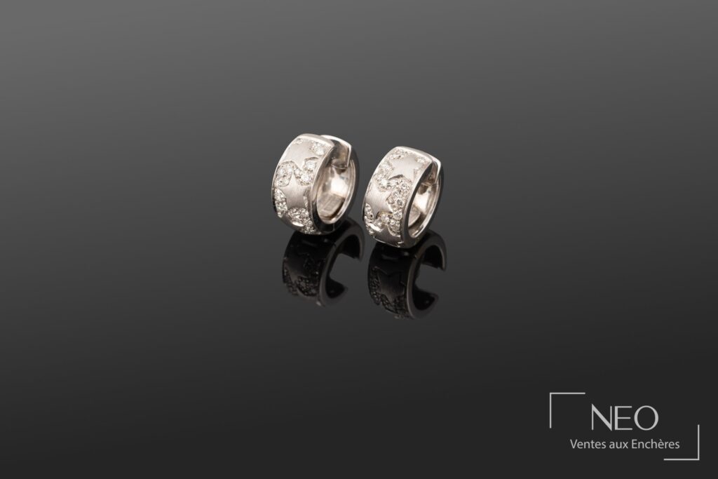Paire de créoles en or gris serties d'étoiles en diamants sur fond sombre