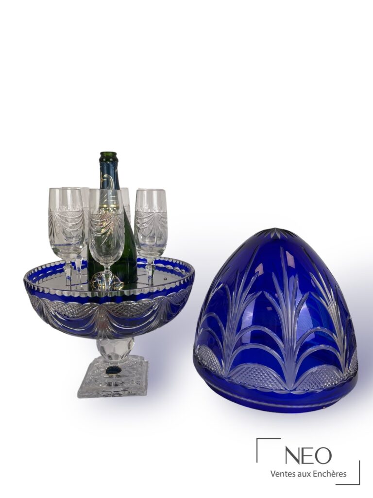 Œuf sur pied en cristal bleu avec six flûtes et une bouteille au centre