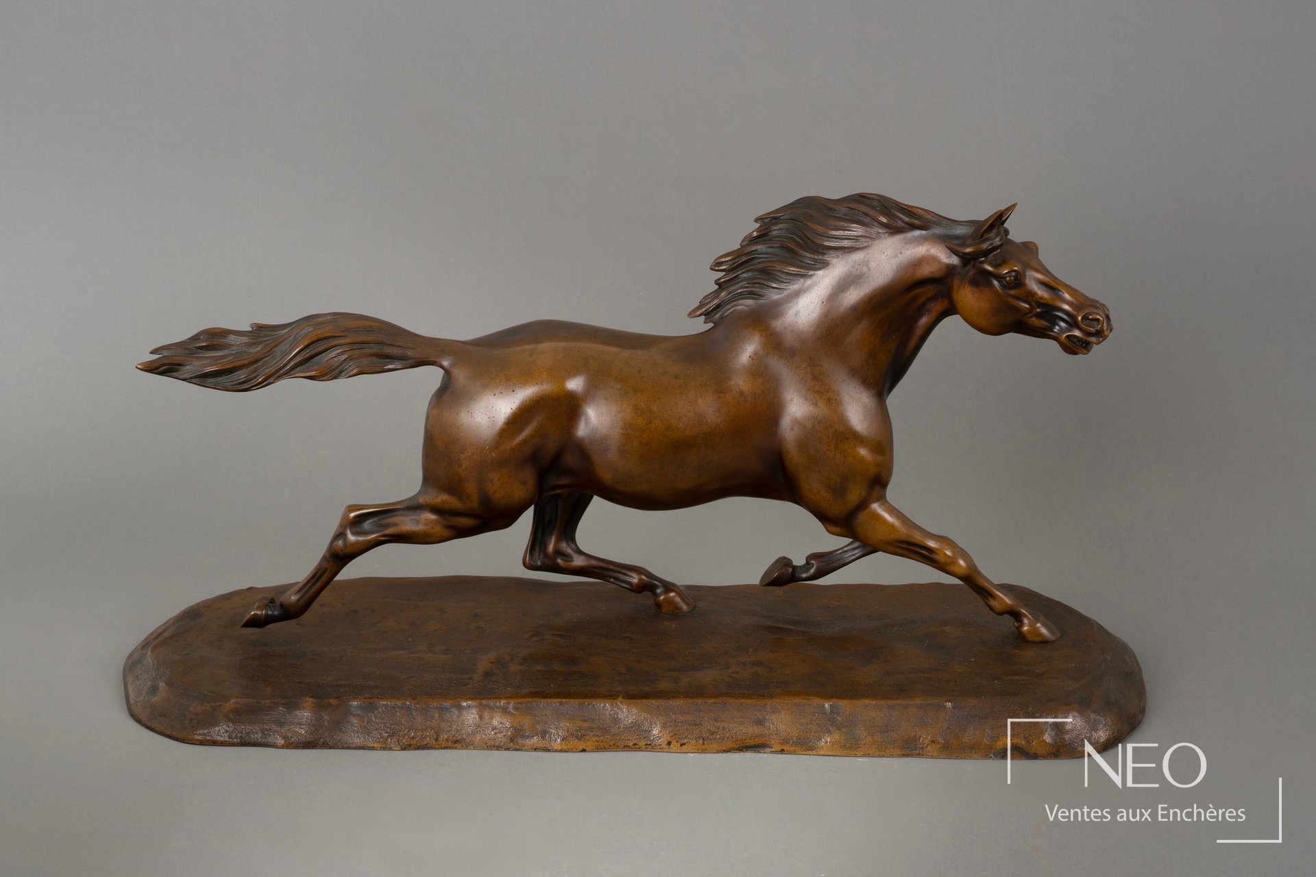 Cheval en bronze lancé au galop sur sa base
