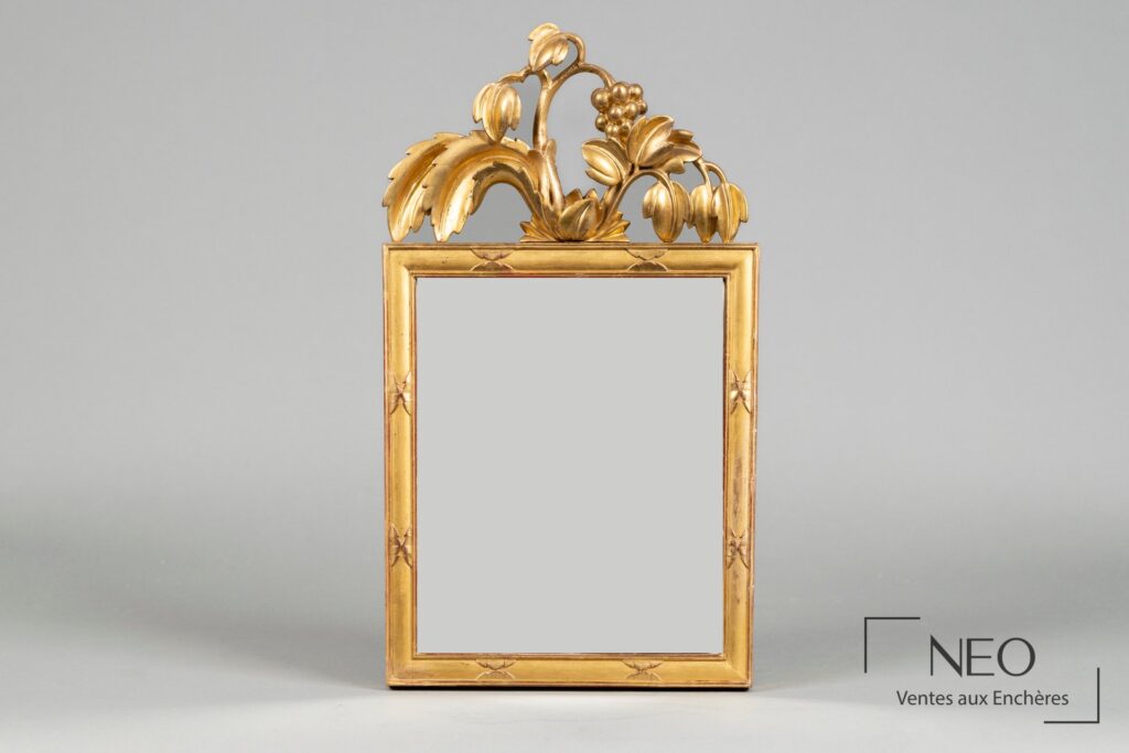 Miroir rectangulaire en bois doré avec fronton à décor de feuillages