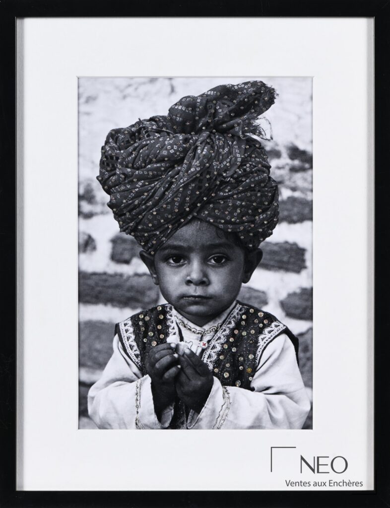 Photographie en noir et blanc encadrée représentant un enfant coiffé d’un grand turban brodé