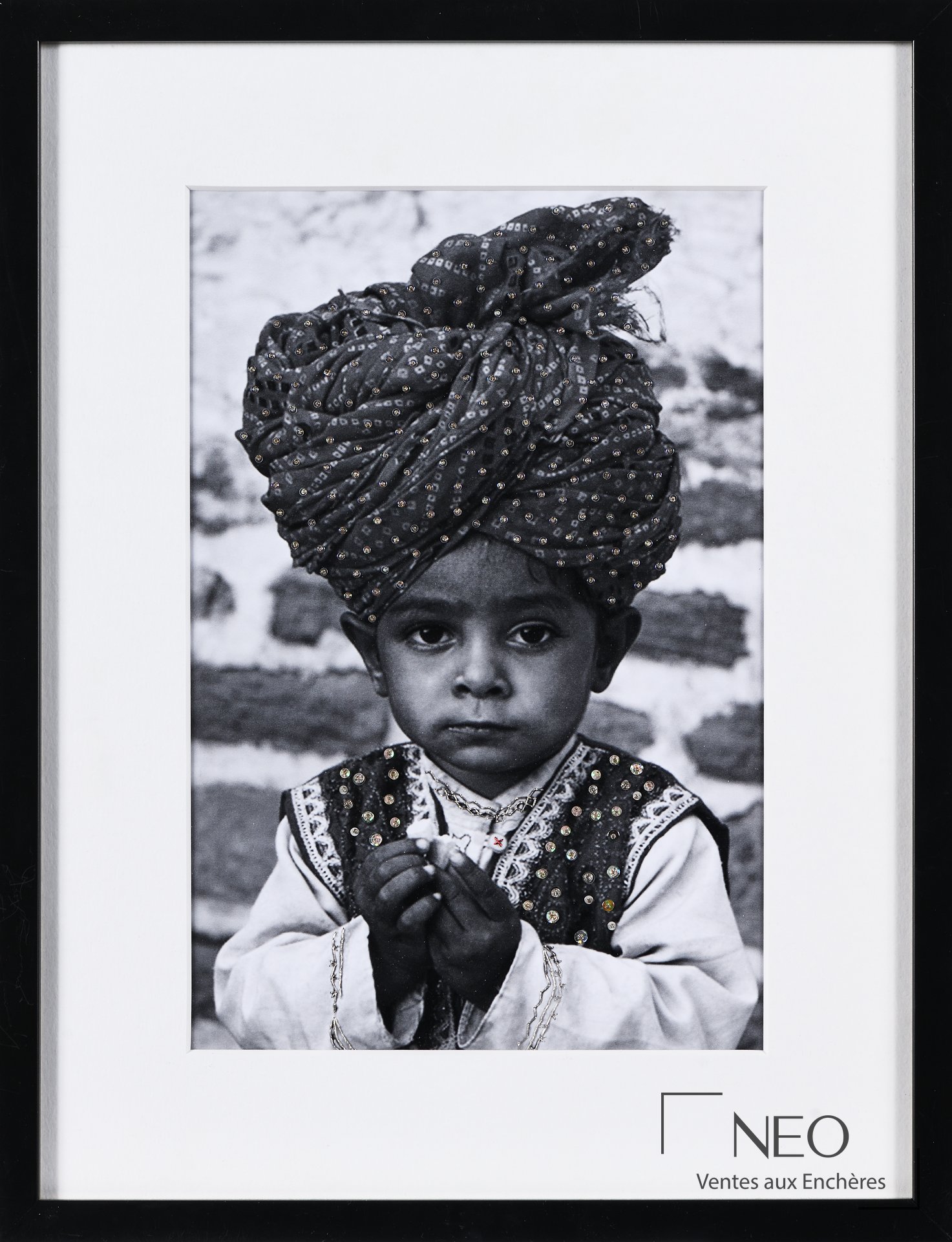 Photographie en noir et blanc encadrée représentant un enfant coiffé d’un grand turban brodé