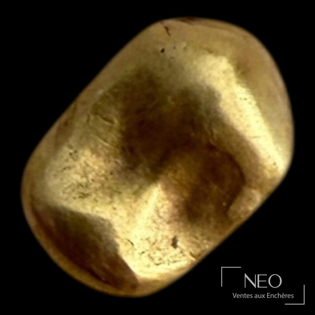 Fragment d'or dentaire de forme irrégulière sur fond noir